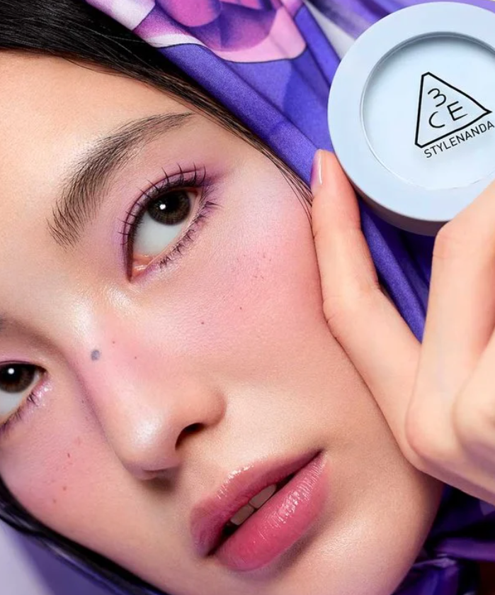 3CE Face Blush, sur maquillage du visage, marque 3CE, boîte en main, fond violet, gros plan beauté