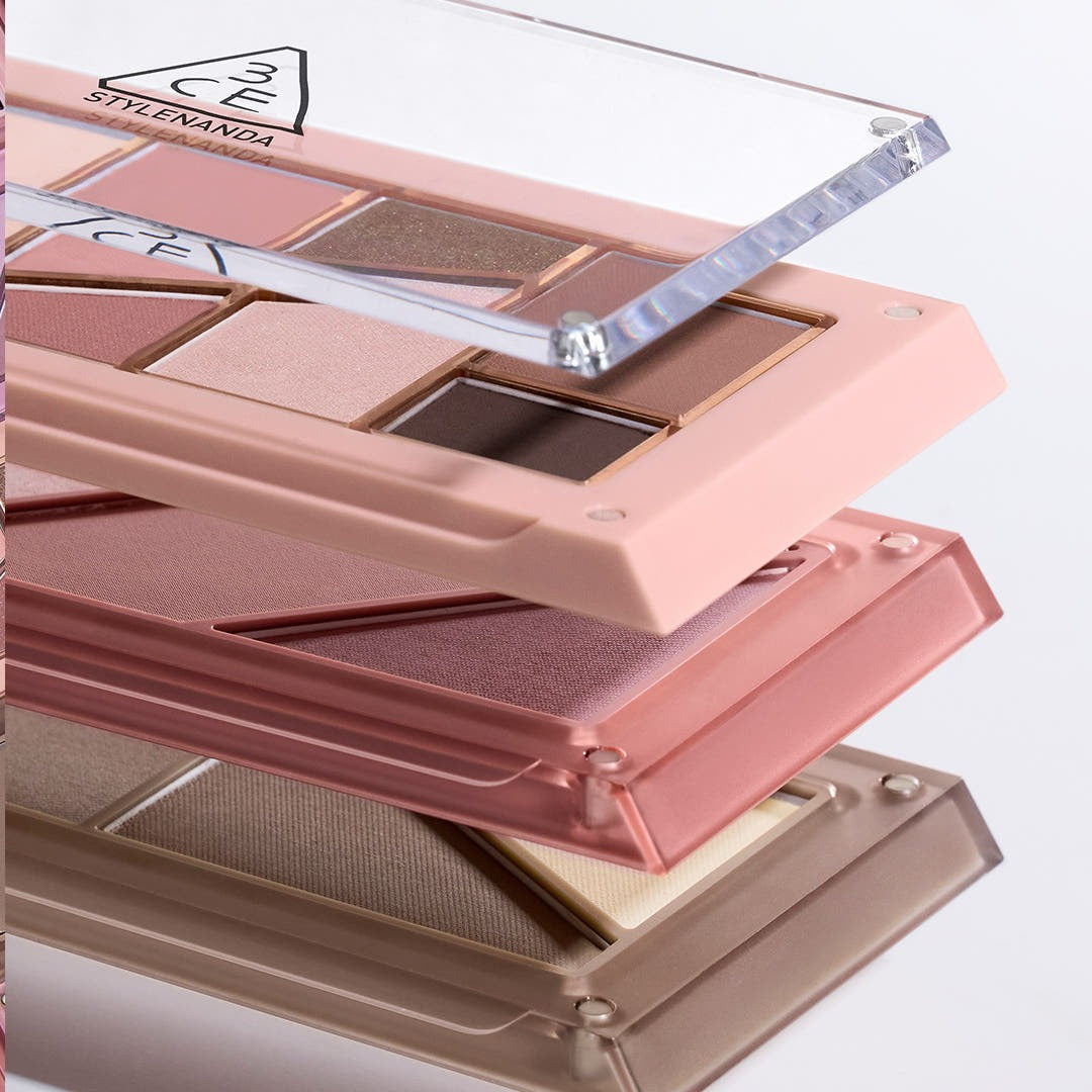3CE Layer It All Contour Palette 9.5g, palette contour maquillage 3CE sur présentoir rose avec reflets sous lumière.