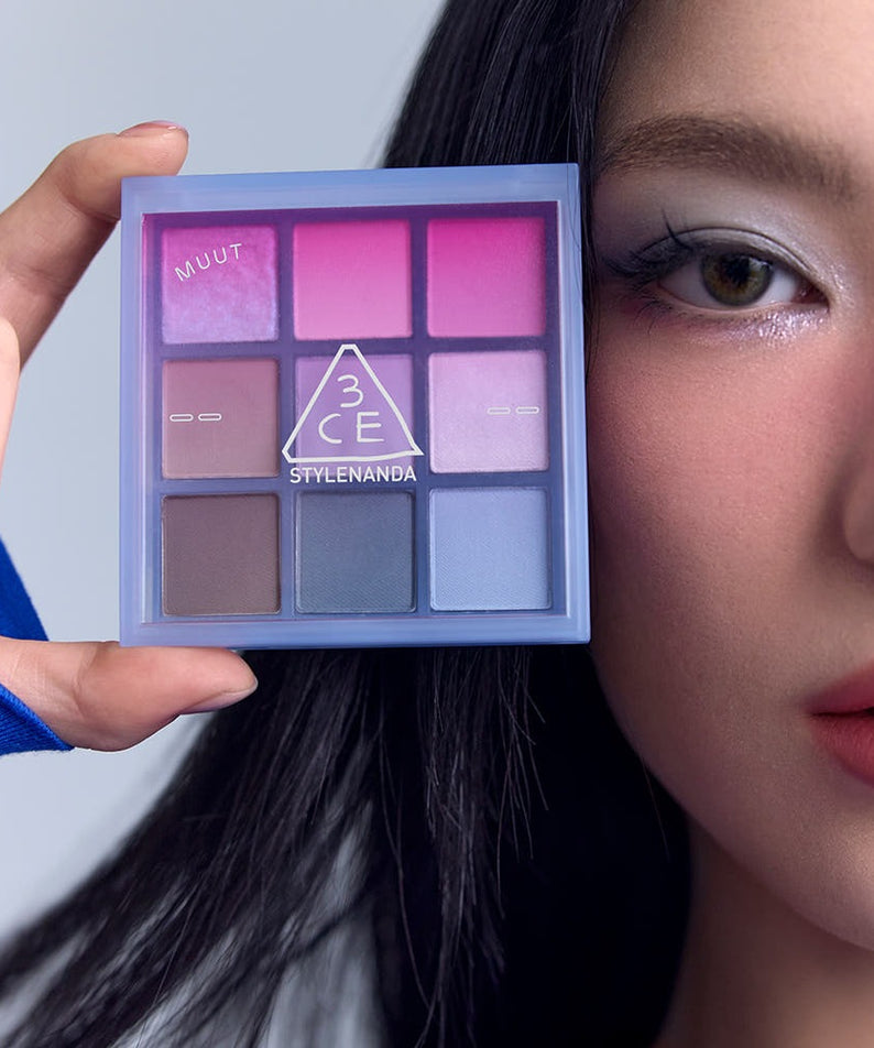 3CE Multi Eye Color Palette 7g, palette maquillage 3CE en main, maquillage yeux violet-rose sur visage, style visuel.