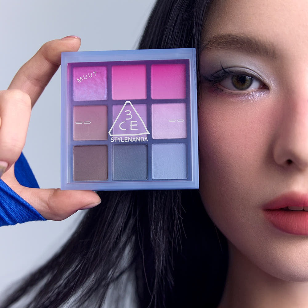 3CE Multi Eye Color Palette 7g, palette maquillage 3CE en main, maquillage yeux violet-rose sur visage, style visuel.