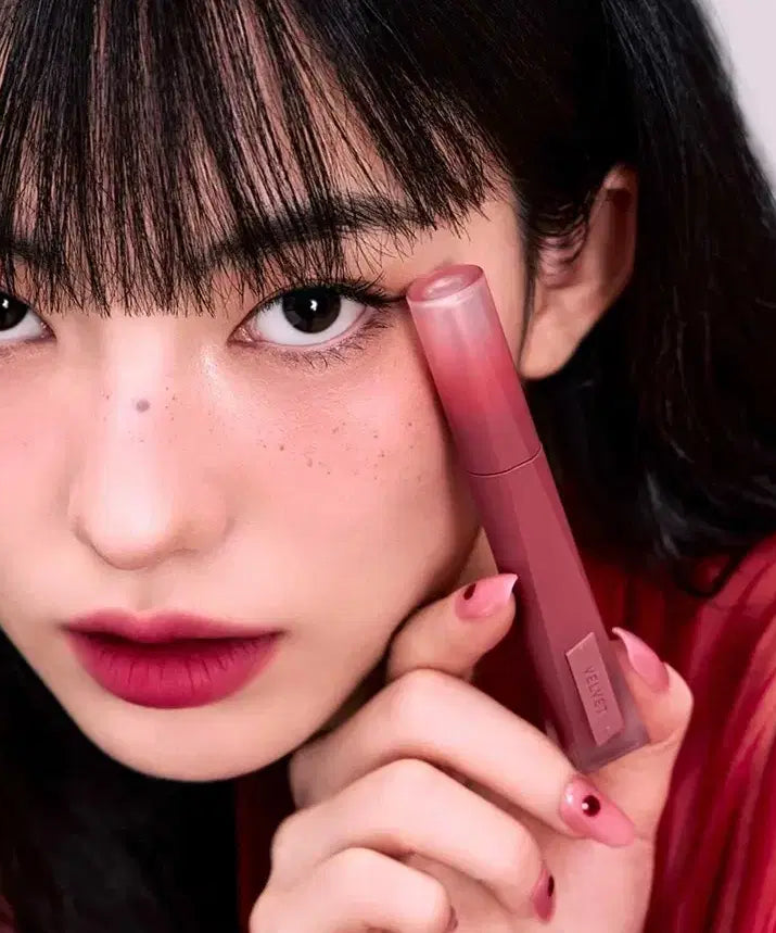 Modèle appliquant le 3CE Velvet Lip Tint Plush pour un look lèvres velours élégant et raffiné.