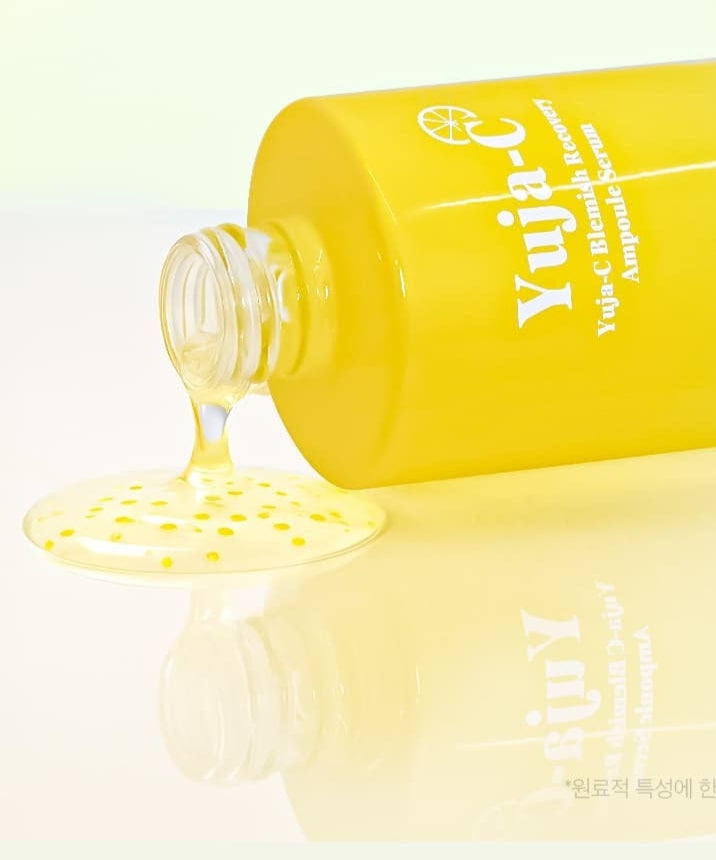 Flacon de 3W CLINIC Yuja C Blemish Recovery Ampoule Serum 100ml renversé avec sérum jaune en train de s'écouler.