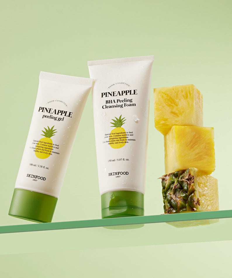 SKINFOOD Pineapple Peeling Gel 100ml : tubes et morceaux d’ananas sur fond vert, skincare anti-douceur.