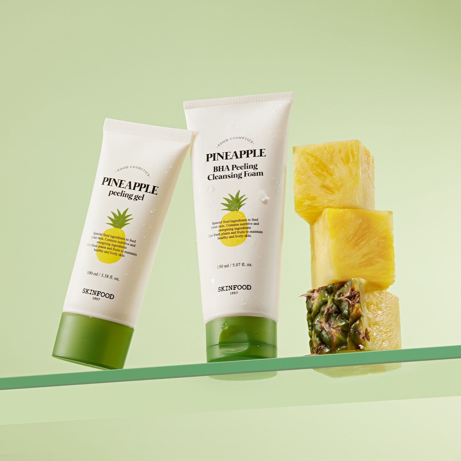 SKINFOOD Pineapple Peeling Gel 100ml : tubes et morceaux d’ananas sur fond vert, skincare anti-douceur.