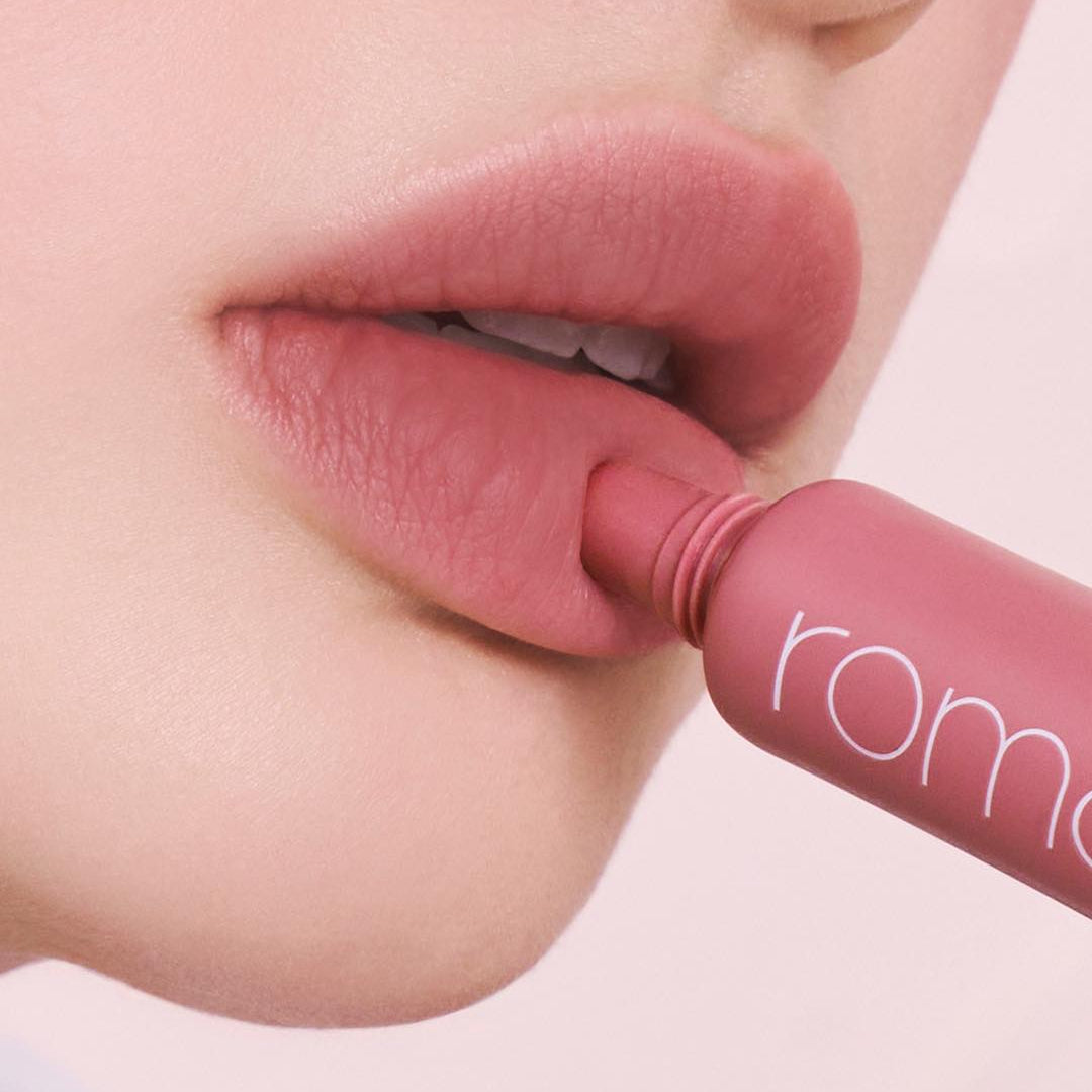 ROMAND Color Lip Matte, gros plan sur des lèvres appliquant le rouge à lèvres de la marque ROMAND sur fond clair