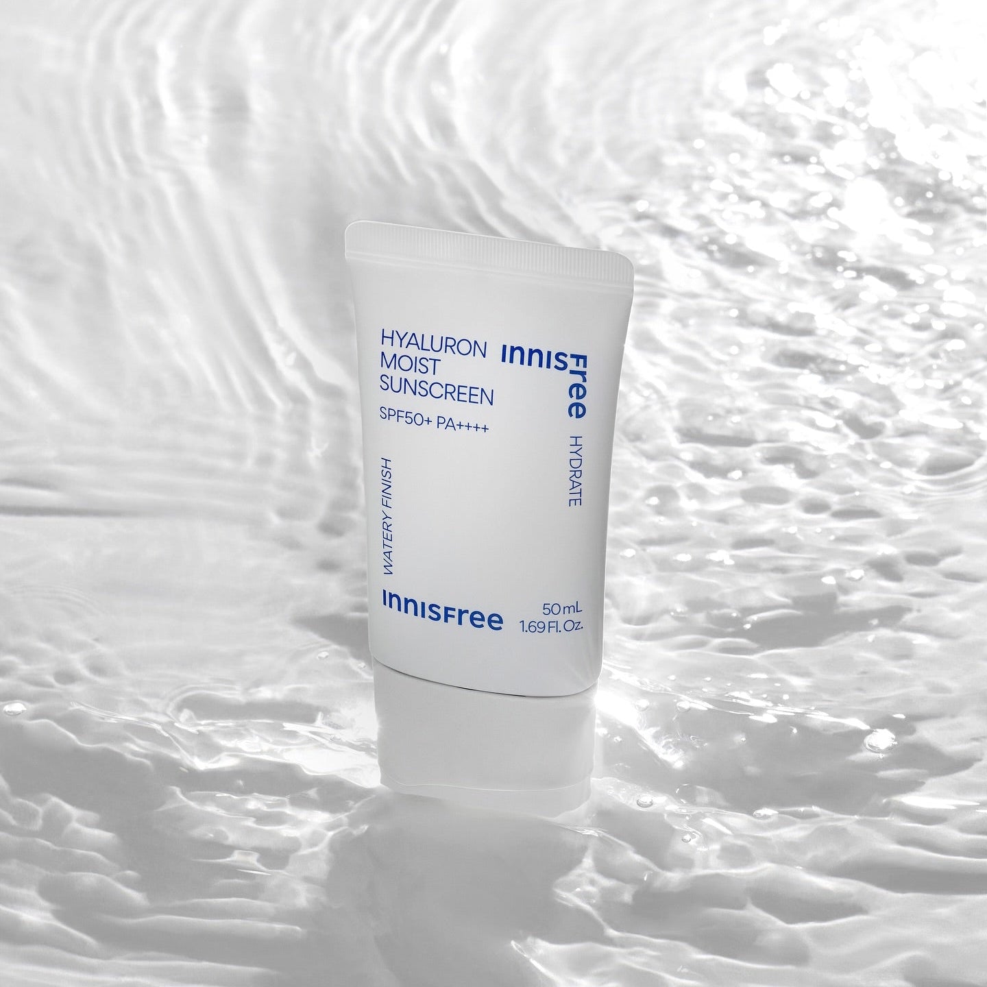 Décris l'image en français en mentionnant le produit INNISFREE Hyaluron Moist Sunscreen 50ml, marque Innisfree, flacon sur fond blanc texturé.