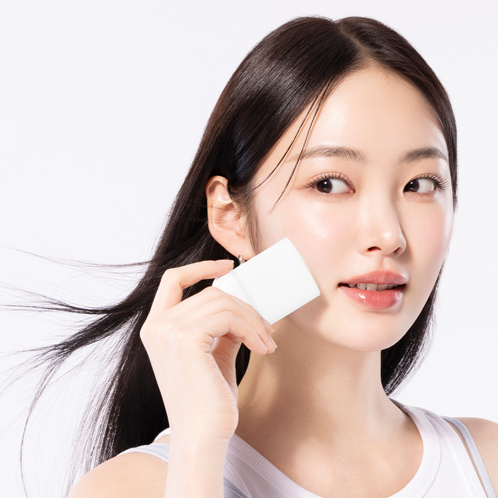 Woman applying COSRX Airy-Light Invisible Sun Stick SPF50+ from Ma Petite Corée for sun protection.