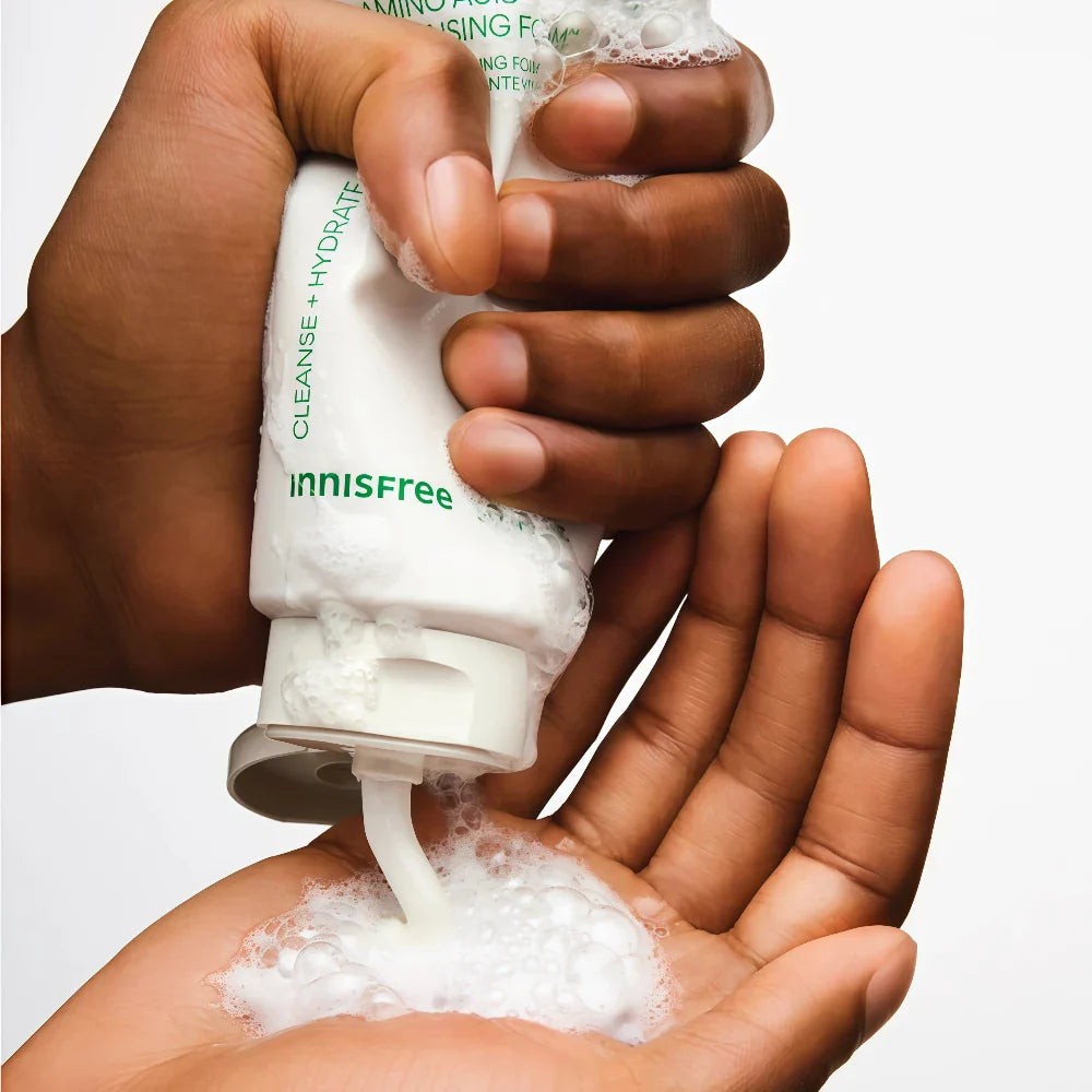 INNISFREE Green Tea Amino Hydrating Cleansing Foam 150g, main tenant le tube et mousse sur la peau (contexte skincare)