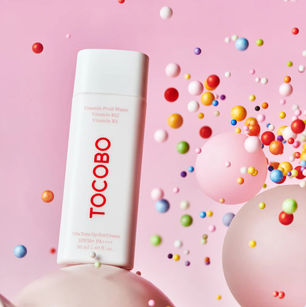 TOCOBO Vita Tone Up Sun Cream 50ml, crème solaire sur fond rose avec billes colorées, style cosmétique en studio