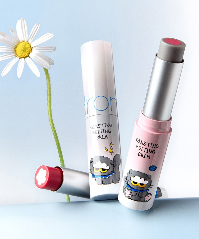 ROMAND x Joanne Friends Glasting Melting Balm sur fond bleu avec une marguerite