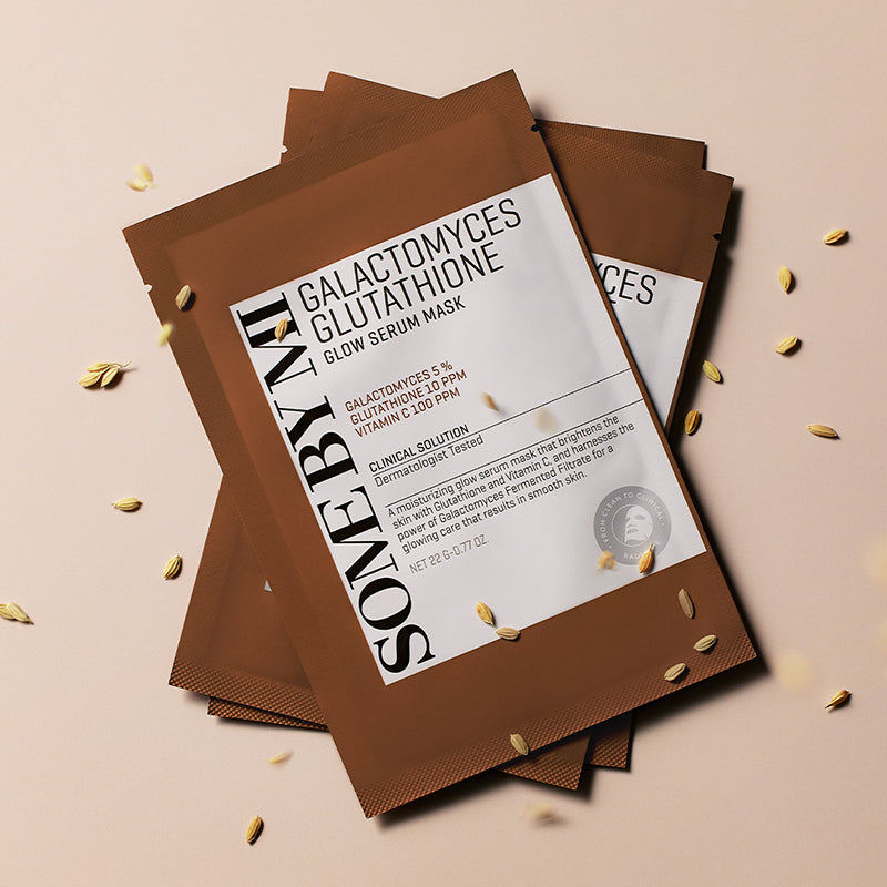 Décris l'image en français : SOME BY MI Galactomyces Glutathione Glow Serum Mask, masques SOMEBYMI sur fond clair avec détails dorés.