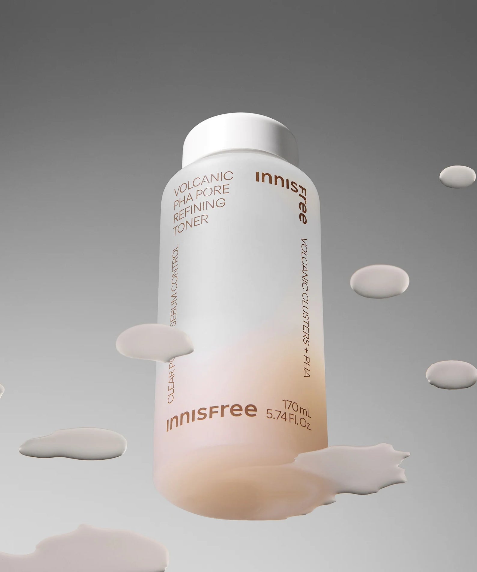 INNISFREE Volcanic PHA Pore Refining Toner 170ml, flacon en studio avec fond gris et éclaboussures blanches.