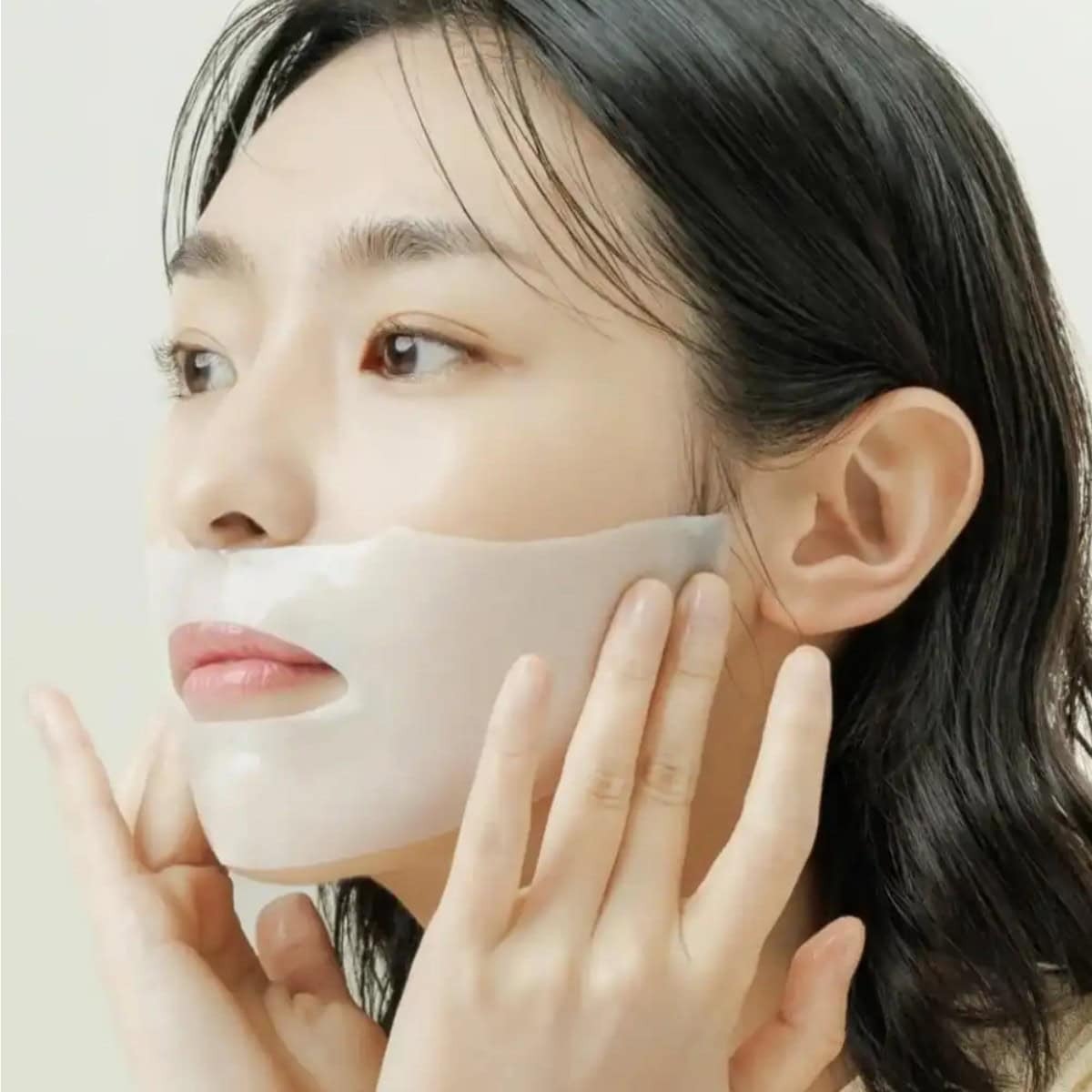 Décris l'image en français : ABIB Collagen Gel Mak Jericho Rose Jelly, marque ABIB, femme applique un gel rosé sur le visage.