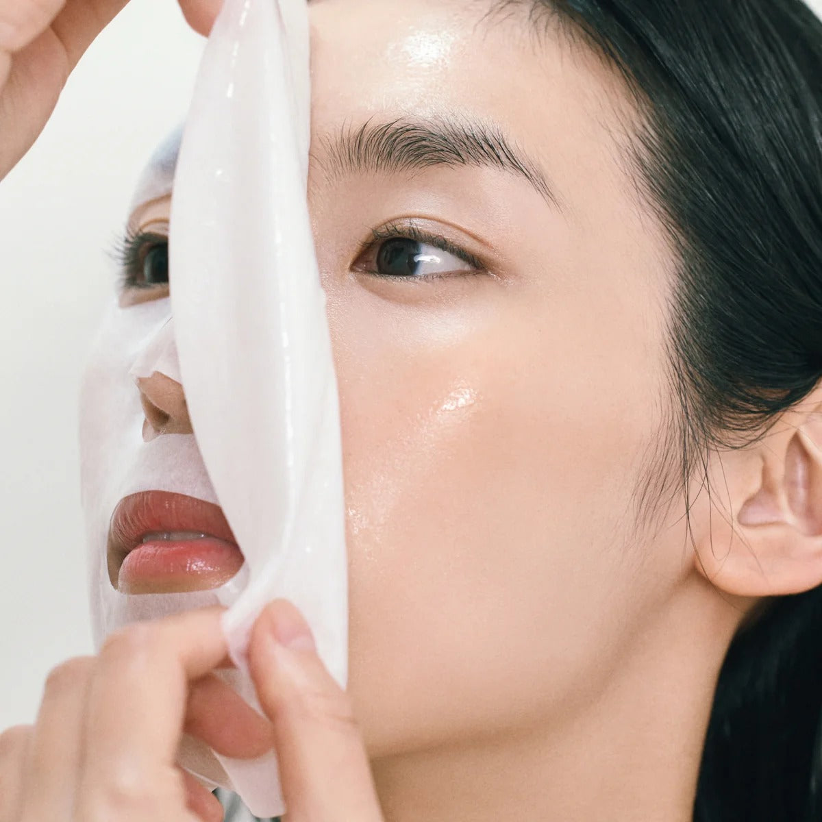 ABIB Gummy Sheets Mask Collagen Milk Sticker : femme applique un masque gommeux au collagène, gros plan lumineux.