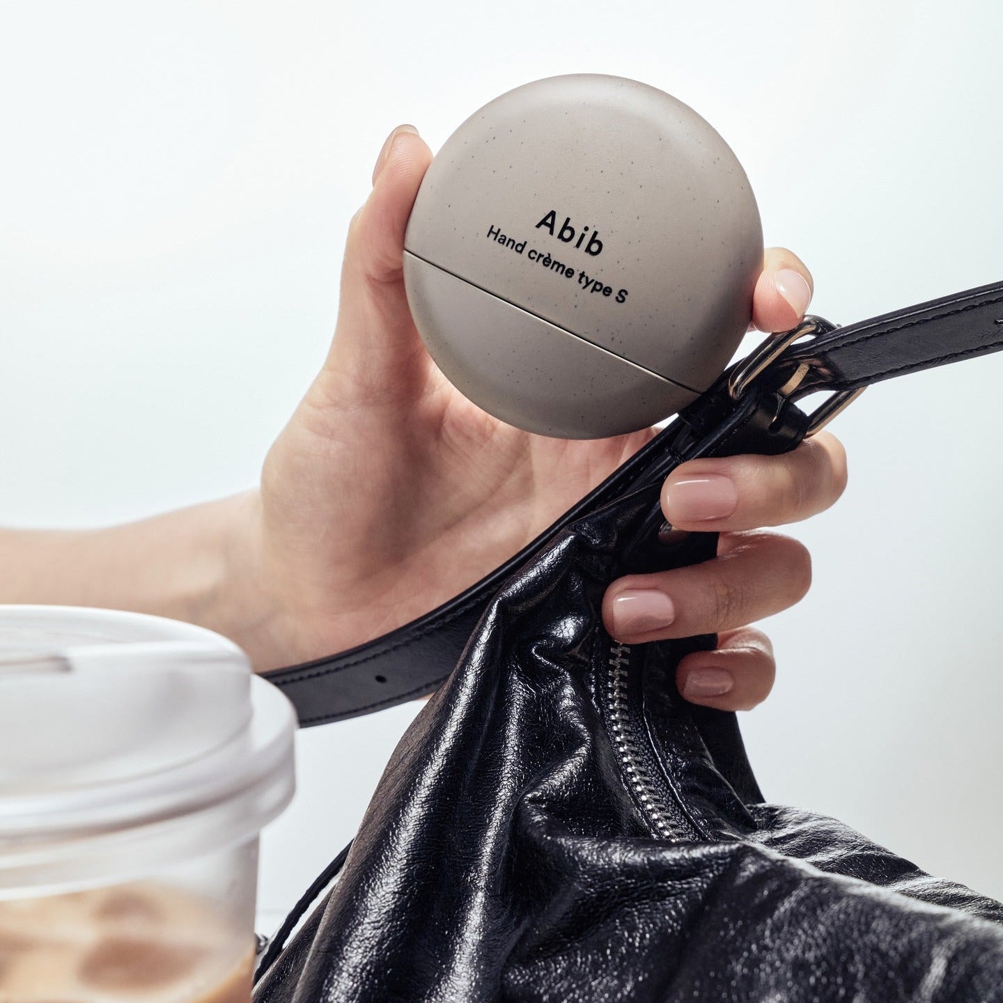 ABIB Hand Cream Type 50ml, crème pour les mains Abib tenue en main, contexte sac en cuir sur fond clair