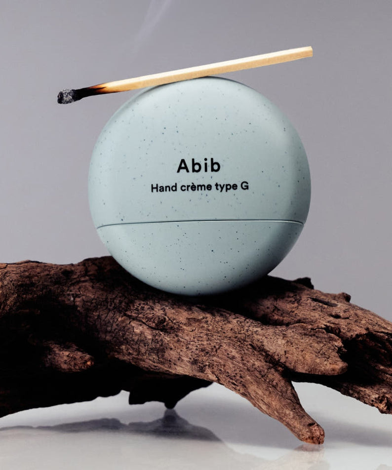 ABIB  Hand Cream Type G 50ml, crème mains Abib sur bois et branche, contexte naturel, pack rond blanc