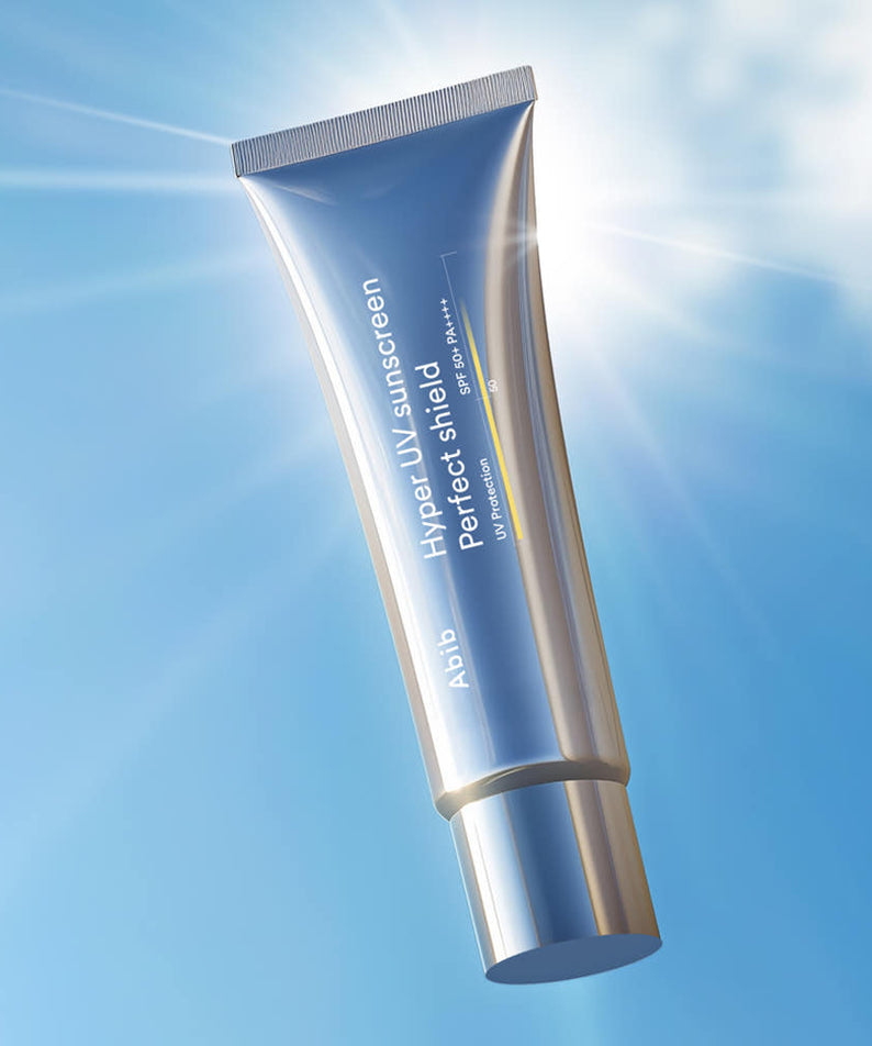 ABIB  Hyper UV Sunscreen Perfect Shield 50ml, tube sur fond bleu ciel, effet solaire, marque ABIB en gros plan