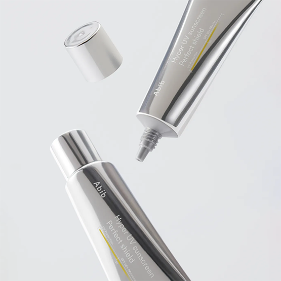 Décris l'image en français : ABIB  Hyper UV Sunscreen Perfect Shield 50ml, tubes de crème solaire sur fond blanc