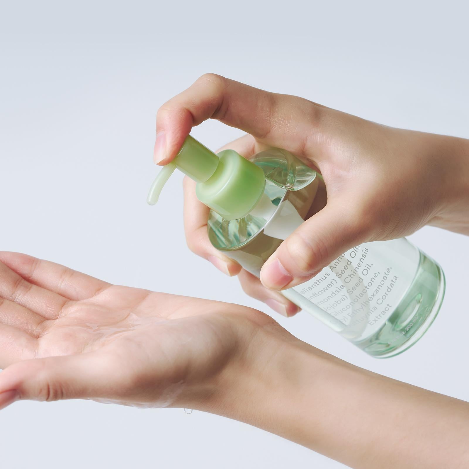 Main tenant ABIB Pore Cleansing Oil Heartleaf Oil-Wash 200ml, huile versée sur visage, esthétique clean