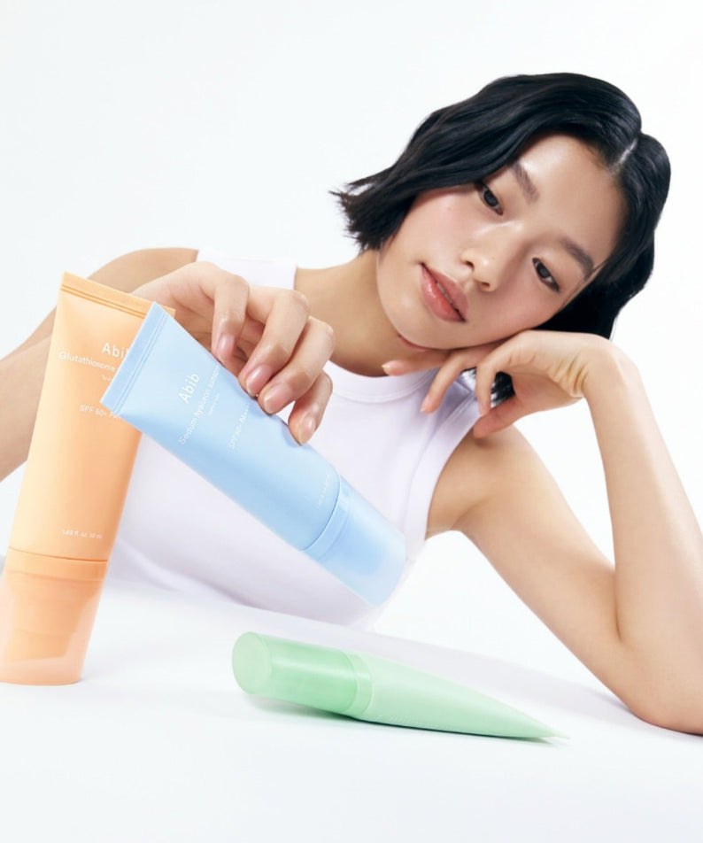 ABIB Sunscreen Tube 50ml 3 Types : tubes solaires ABIB sur fond clair, modèle tenant les produits, rendu photo.