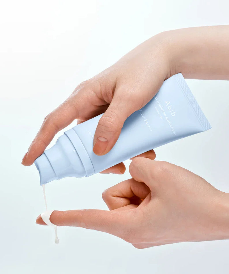 ABIB Sunscreen Tube 50ml 3 Types, crème solaire en tube bleu, mains appliquant sur peau, fond clair, marque ABIB
