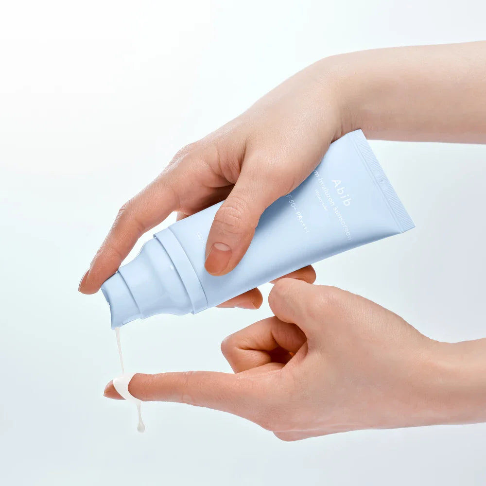 ABIB Sunscreen Tube 50ml 3 Types, crème solaire en tube bleu, mains appliquant sur peau, fond clair, marque ABIB