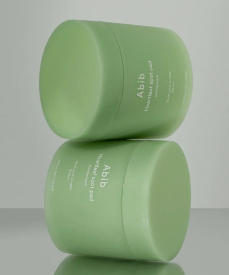 Produit "ABIB Heartleaf Spot Pad Calming Touch 70 pads" en deux pots verts, idéal pour apaiser et rafraîchir la peau.