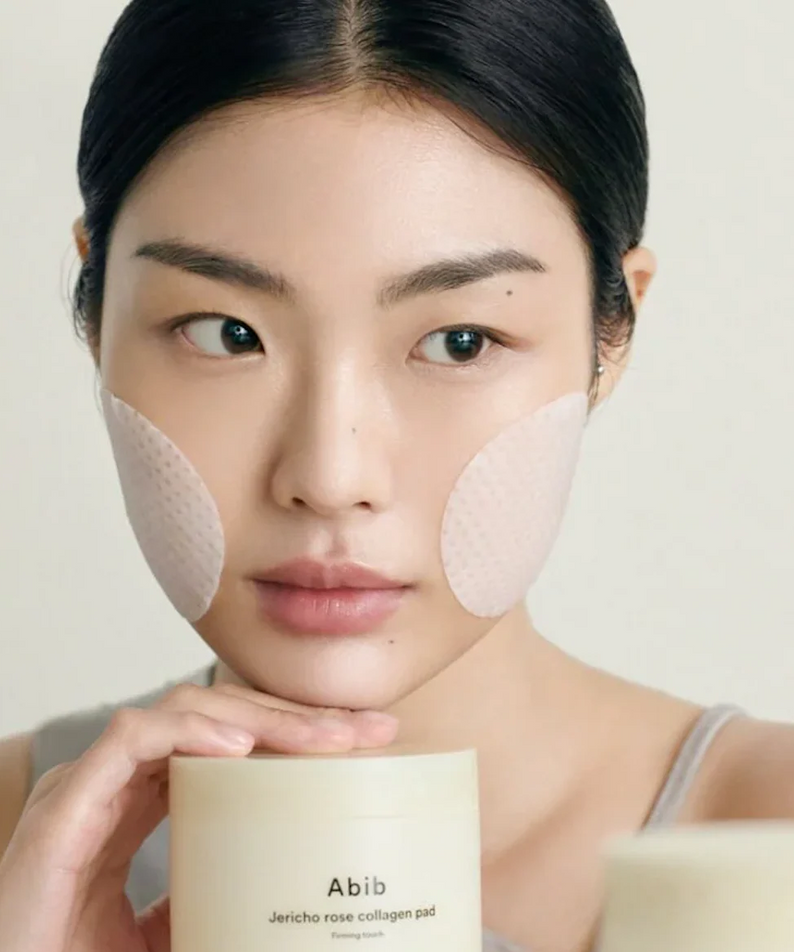 ABIB Jericho Rose Collagen Pad Firming Touch 60 Pads sur le visage d'une femme. Soin raffermissant et hydratant.