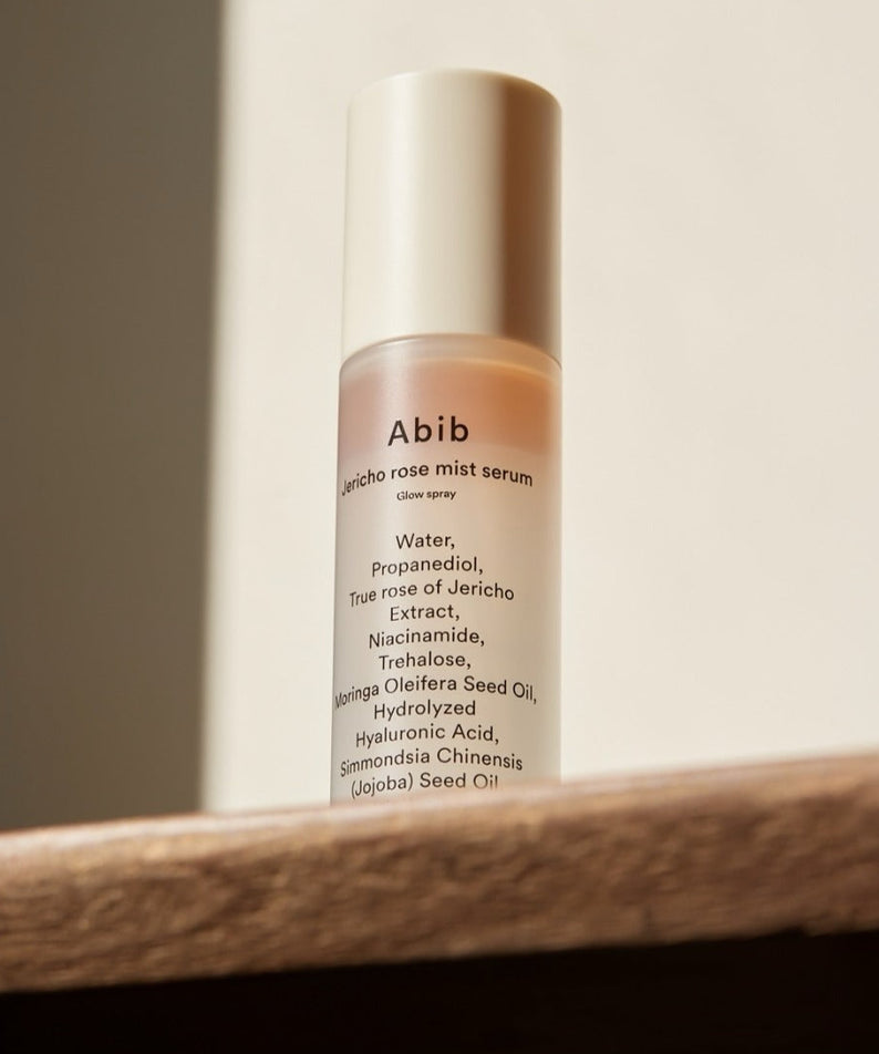 ABIB Jericho Rose Mist Serum Glow Spray 100ml sur une étagère en bois, brume éclat hydratante pour une peau lumineuse.