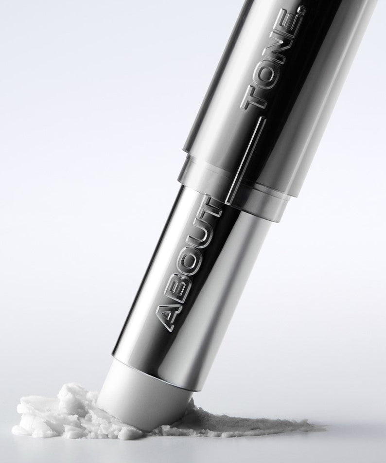 ABOUT TONE Blur Lasting Stick Primer sur une surface blanche, mettant en avant sa texture et sa finition élégante.