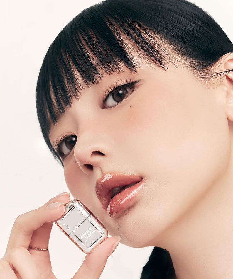 ABOUT TONE Lab Fit Gloss Mini 2g, gloss nude sur lèvres; femme en gros plan, boîte visible sur fond clair.