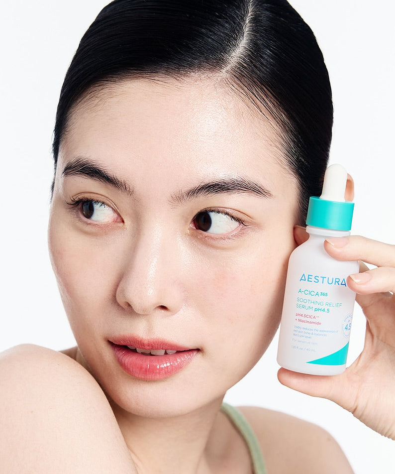 Décris l'image en français : AESTURA  A-cica 365 Soothing Relief Serum pH4.5 40ml, femme applique sérum apaisant sur peau