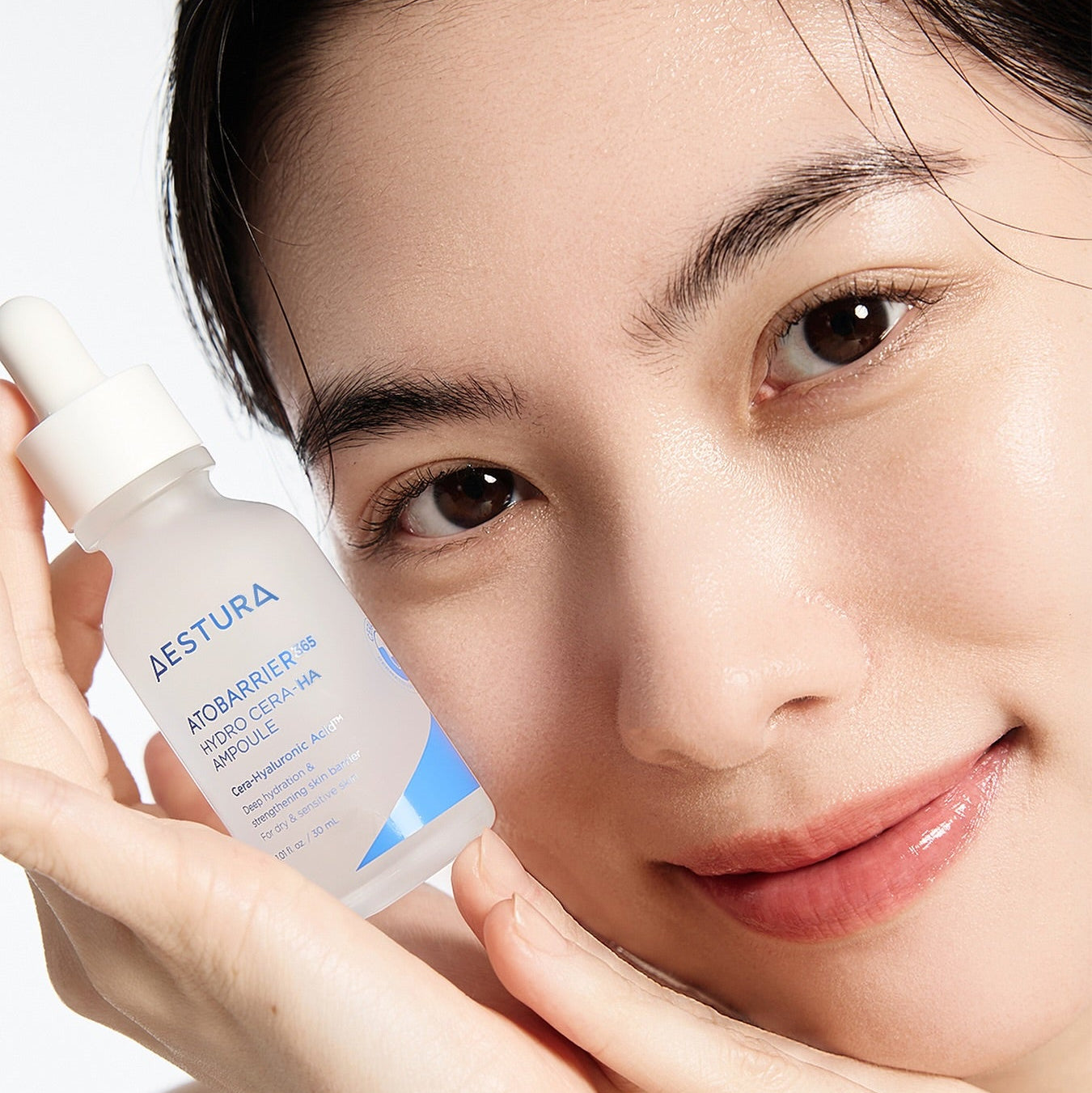 AESTURA  Atobarrier 365 Hydro Cera-HA  Ampoule 30ml : sérum sur visage, femme à côté du flacon, soin hydratant.