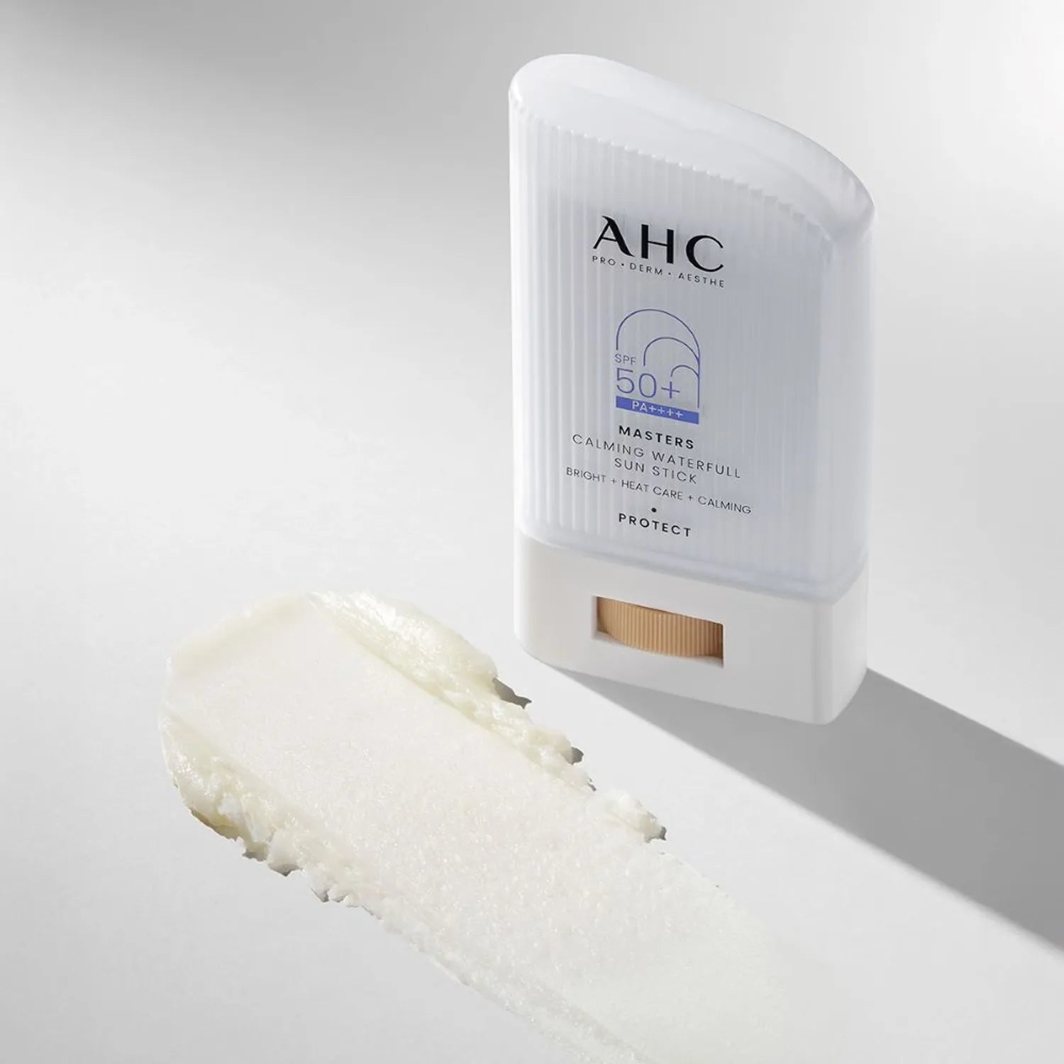 AHC Masters Calming Waterfull Sun Stick 22g d’AHC, stick solaire apaisant posé sur fond clair, texture crème visible.