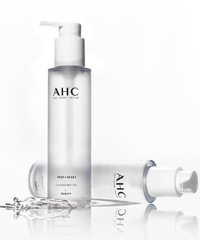 AHC Prep Reset Cleansing Oil 125ml : flacon pompe AHC sur fond blanc, avec éclaboussures d’huile et eau.