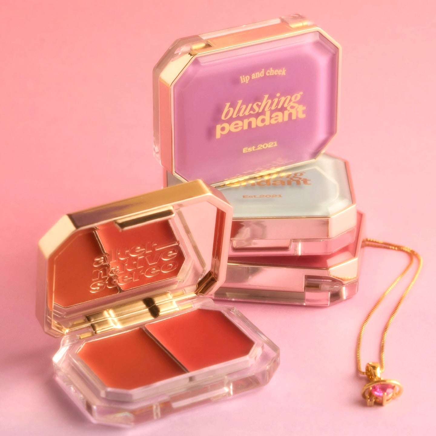 ALTERNATIVE STEREO Blushing Pendant Lip & Cheek, marque Alternative Stereo, pendentif maquillage sur fond rose, coffret.