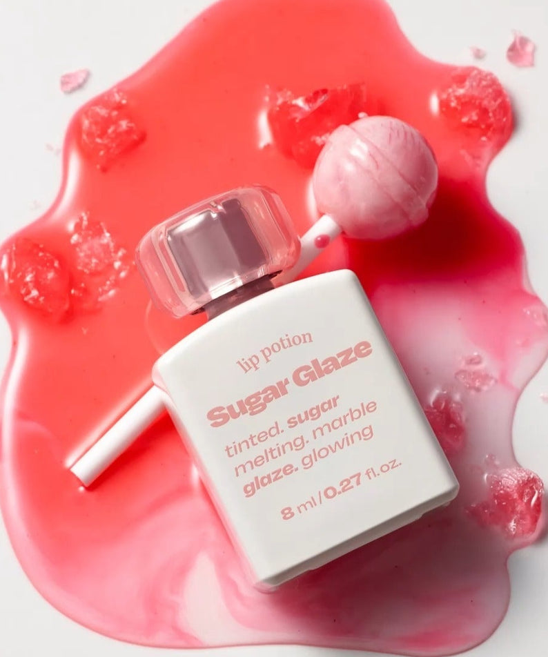 ALTERNATIVE STEREO Lip Potion Sugar Glaze posé sur éclaboussure rose, design esthétique et séduisant.