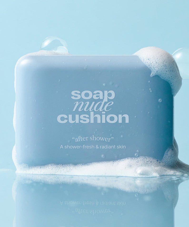Savon ALTERNATIVE STEREO Soap Nude Cushion SPF42 PA++ avec mousse, sur fond bleu, apportant une peau radieuse et fraîche après douche.
