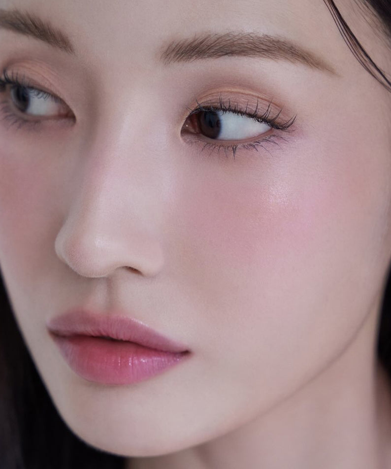 Visage féminin avec maquillage doux, mettant en valeur AMELI Night Series Touch Balm pour un éclat naturel et lumineux.