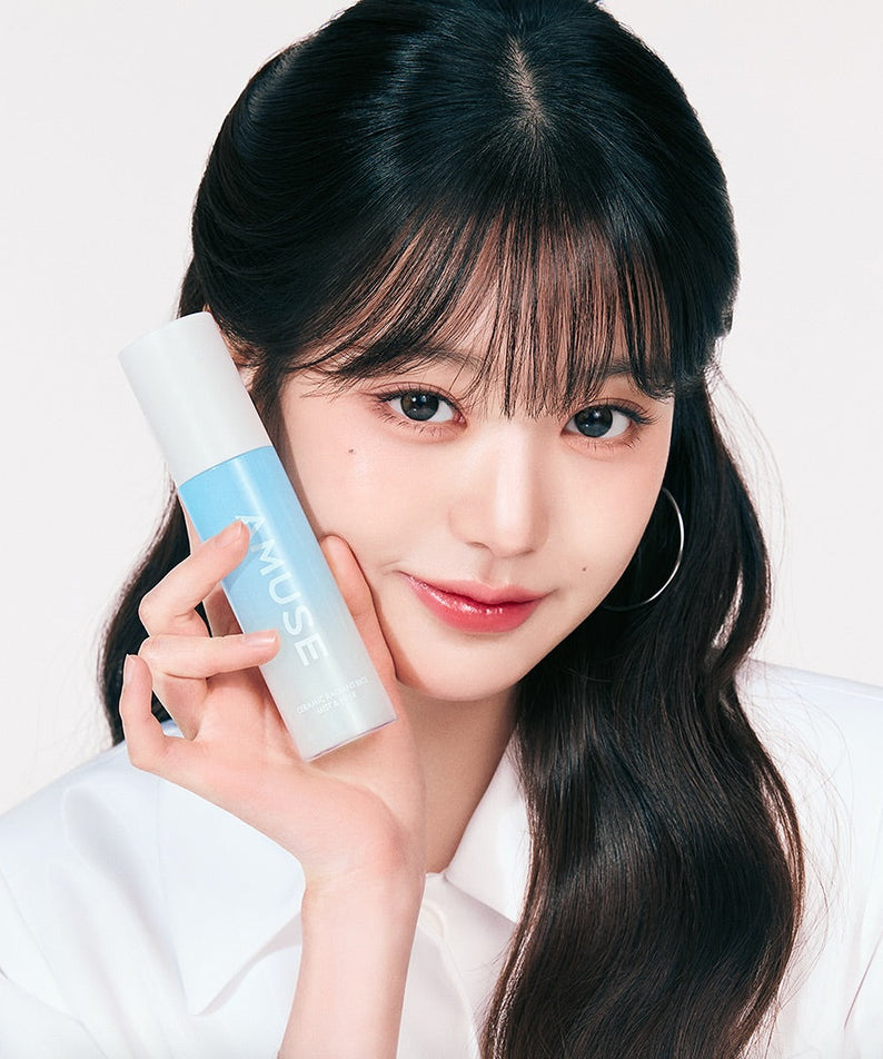 AMUSE Ceramic White Pearl Rice Mist & Fixer 80ml tenue par une femme souriante, produit cosmétique élégant et efficace.