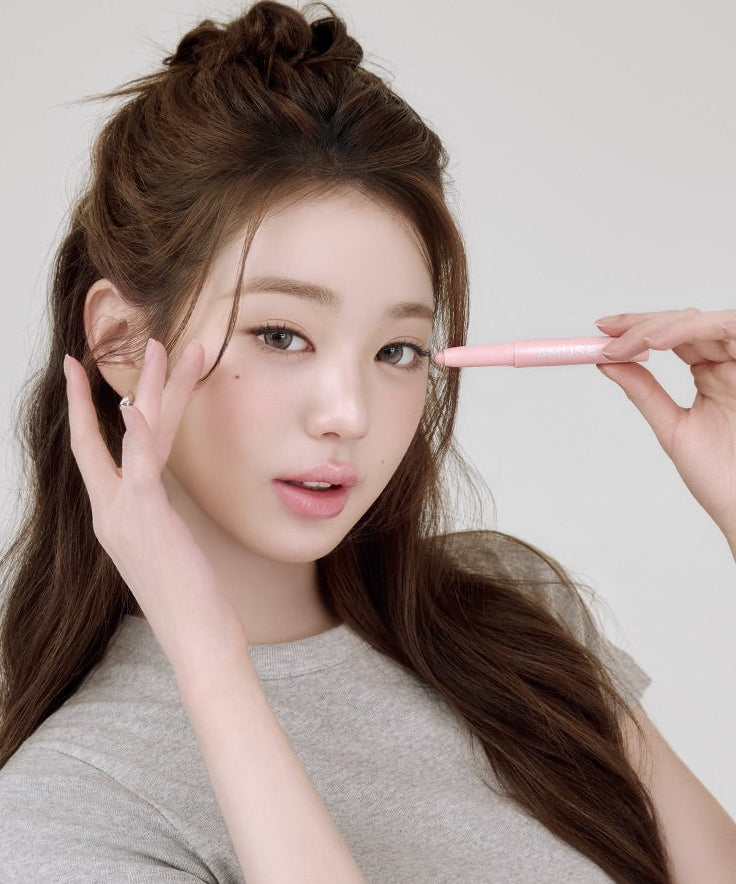 Décris l'image : AMUSE Everlasting Eye Pencil 6 Colors, la marque, avec une femme tenant un crayon rose maquillage des yeux.
