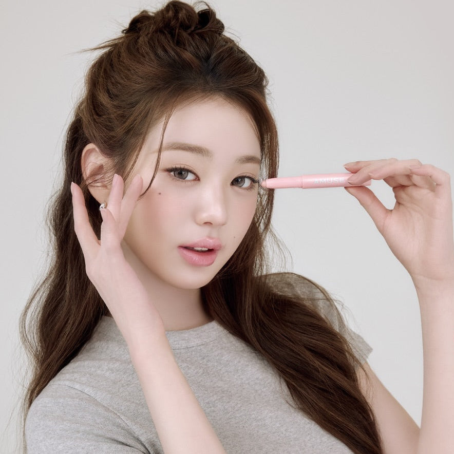Décris l'image : AMUSE Everlasting Eye Pencil 6 Colors, la marque, avec une femme tenant un crayon rose maquillage des yeux.