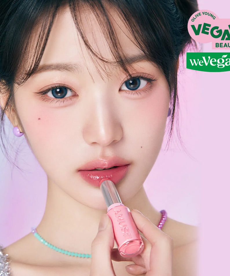 Femme appliquant AMUSE Fondue Balm, cosmétique vegan. Parfait pour beauté naturelle. Focus sur lèvres rosées, esthétique douce.