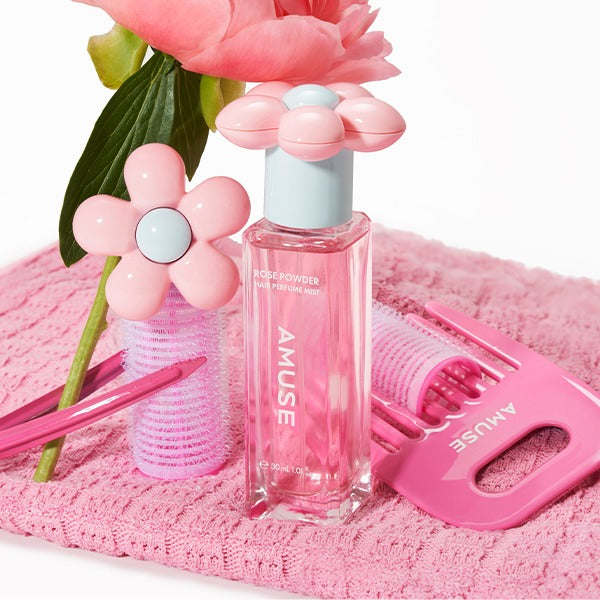 AMUSE Rose Powder Hair Perfume Mist 30ml d’AMUSE sur serviette rose, fleurs et accessoires coiffure, visuel produit cosmétique.
