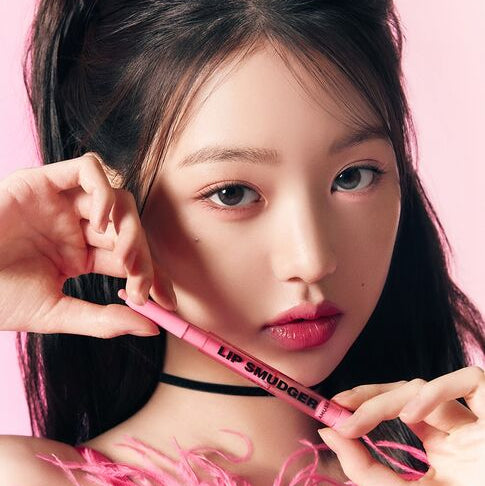 AMUSE Lip Smudger : produit maquillage lèvres sur une femme, tube rose et pose mains, fond rose