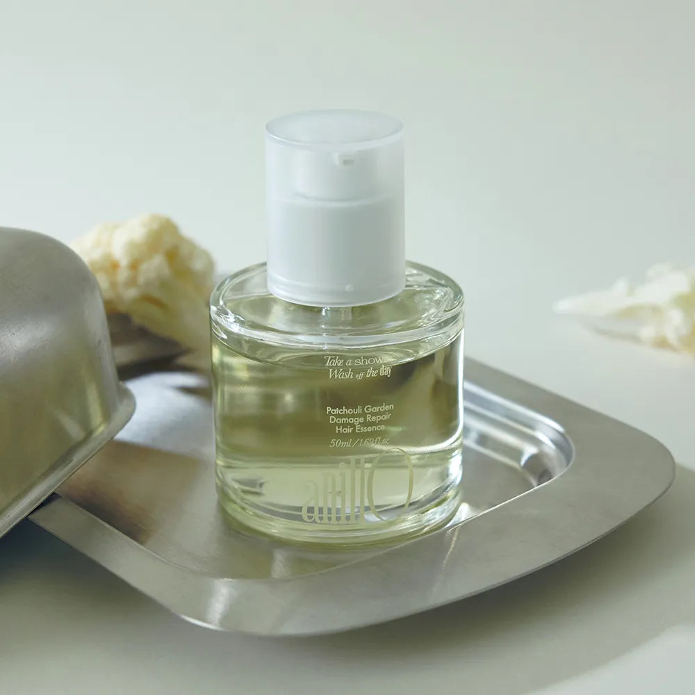 ANILLO Patchouli Garden Damage Repair Hair Essence 50ml, flacon sur plateau en métal, contexte salle de bain, fond clair.