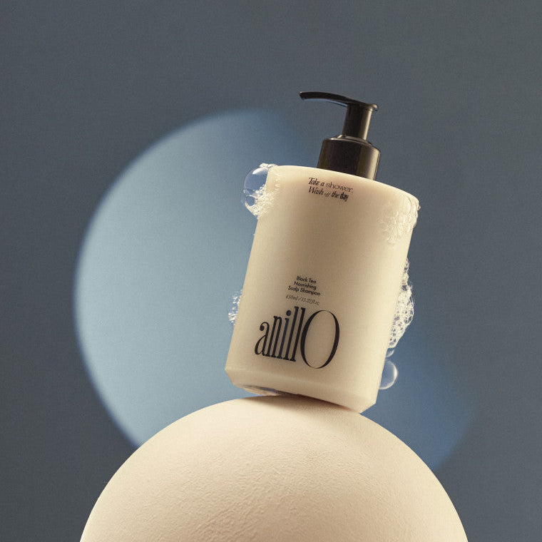 ANILLO Black Tea Nourishing Scalp Shampoo 450ml de la marque ANILLO sur fond bleu, flacon noir et emballage crème.