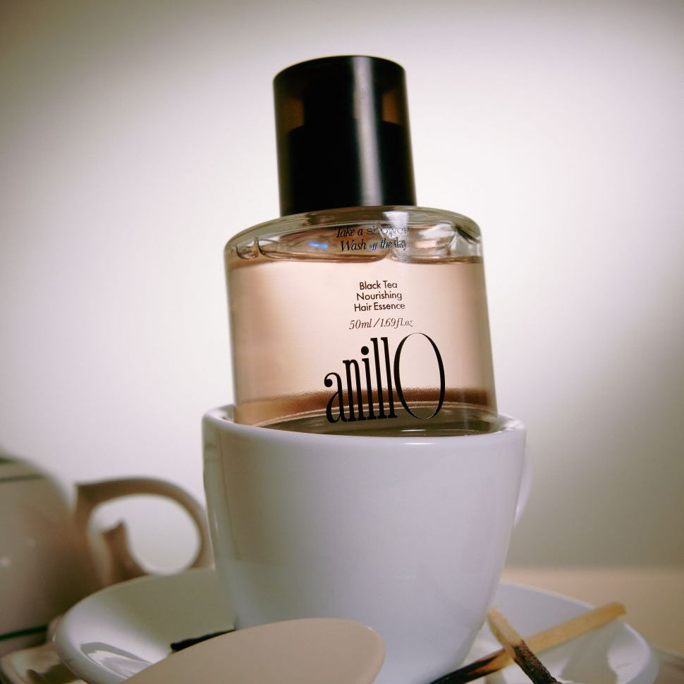 ANILLO Black Tea Nourishing Hair Essence 50ml, flacon en verre noir sur fond salle de bain, marque ANILLO