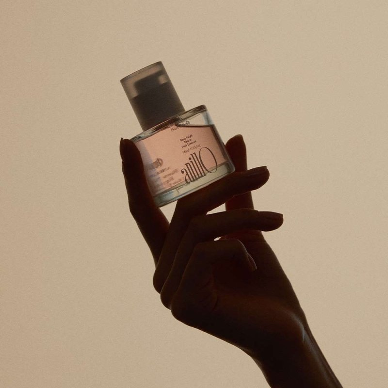 ANILLO Rosy Night Repair Hair Essence 50ml, flacon tenu par une main, fond beige, photo produit nocturne