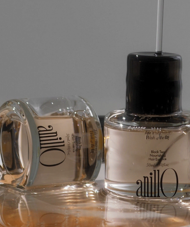 ANILLO Black Tea Nourishing Hair Essence 50ml : flacon noir et blanc sur fond clair, photo produit en studio.